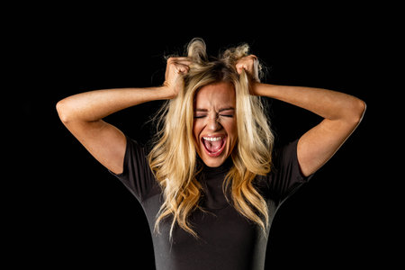 An attractive blonde model poses in a studio environment