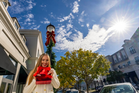 A gorgeous blonde model enjoys a warm day during the Christmas holiday season to do some local shoppingの写真素材