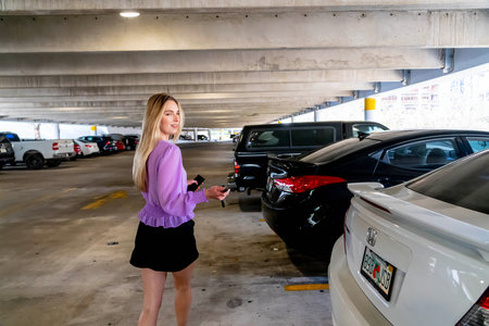 A gorgeous blonde model walks to her car in a covered parking garage after a successful meetingの写真素材