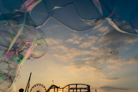 Sunset view of a pier on the California coast with liquid bubbles in the foregroundの写真素材