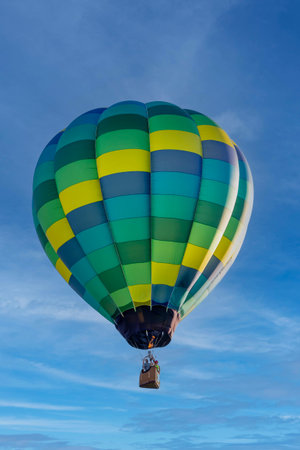 Dazzling balloons dance in the blue sky, a vibrant spectacle of colors floating joyfully across the heavensの写真素材