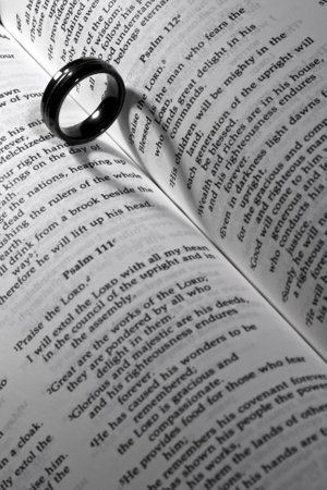 Symbolic union: Wedding band rests on the Book of Mormon, casting a heart-shaped shadow, embodying love, honor, and commitment.の写真素材