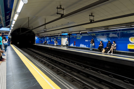 At Almudena Madrid's Puerta de AtochaâAlmudena Grandes station, commuters await trains amidst bustling crowds, immersed in the vibrant rhythm of urban life.のeditorial素材