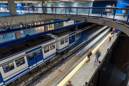 At Almudena Madrid's Puerta de AtochaâAlmudena Grandes station, commuters await trains amidst bustling crowds, immersed in the vibrant rhythm of urban life.のeditorial素材