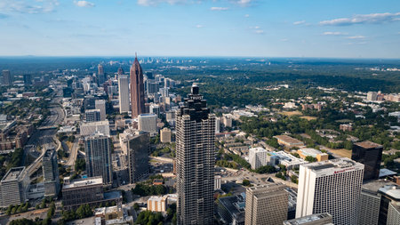 Aerial views of Atlanta showcase a vibrant cityscape with sleek skyscrapers, lush green spaces, and iconic landmarks like Mercedes-Benz Stadium. Highways, railroads, and hills weave through this bustling metropolis.のeditorial素材