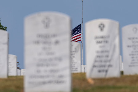 Generic views of a veterans cemetery on a serene day, featuring American flags fluttering in the...