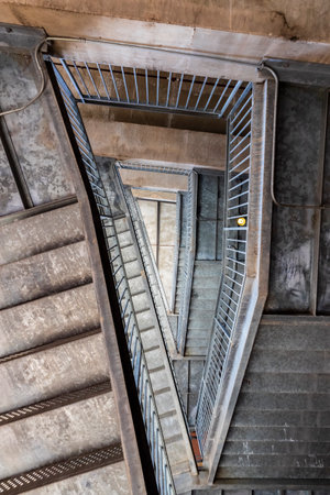 Aerial view of a cement staircase showcases its abstract design, revealing multiple floors. The...
