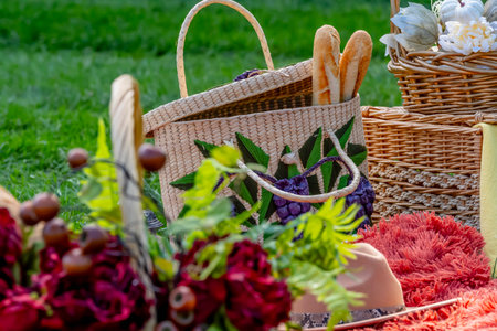 A vibrant fall picnic spread features colorful seasonal foodsâbright pumpkins, apples, charcuterie, fresh bread, cheese, and warm drinks. Surrounded by golden leaves and cozy blankets in the crisp autumn air.の写真素材