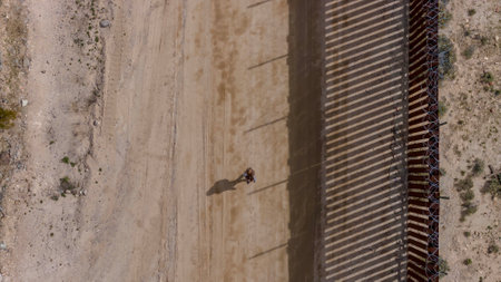 Desperate migrant navigates the Jacumba border wall, seeking illegal entry into the United States,...