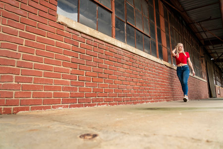 A beautiful blonde woman poses joyfully for the camera, showcasing her stylish spring clothing. With a bright smile and playful demeanor, she radiates happiness, embracing the upcoming gorgeous weather.の写真素材