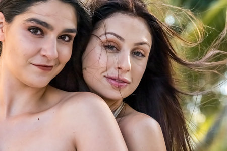 Two gorgeous women embrace their Caribbean vacation, posing for the camera with radiant smiles. Surrounded by stunning scenery, they capture the beauty, adventure, and joy of their unforgettable getaway.の写真素材