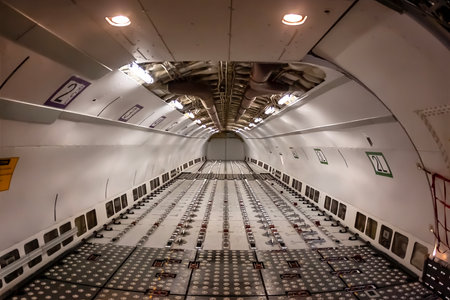 A commercial cargo aircraft rests on the tarmac of a bustling international airport, its massive...