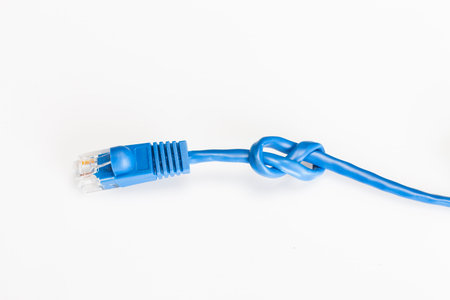 A blue ethernet cable isolated on a white background with a knot in the cordの写真素材