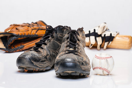 Used baseball cleats against a white backgroundの写真素材