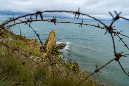 Walking the sands of Omaha Beach, the echoes of D-Day's fierce battle linger in the air. Waves crash where soldiers once fought. The vastness of the sea contrasts with the solemn memories of bravery and sacrifice.の写真素材