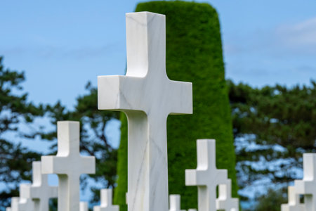 Standing among the endless rows of white crosses at the Normandy American Cemetery, the weight of history is palpable. The somber silence is broken only by the breeze, a poignant reminder of the sacrifices made.の写真素材