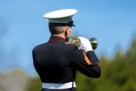 A poignant moment unfolds as a Marine plays taps, honoring a fallen veteran with a solemn salute,...