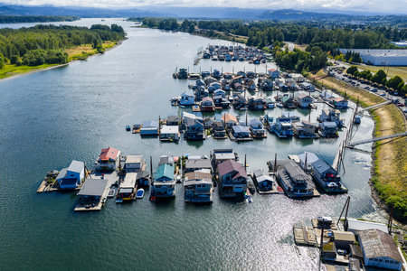 Floating homes float serenely on the Columbia River near Portlandâ€”clustered alongside docks,...
