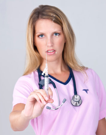 A young medical professional showcases her work in a bright studio with a clean white backdrop, confidently demonstrating tools and techniques that highlight her expertise and dedication.の写真素材