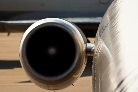 A close up view of a commercial aircraft parked at the airport gate, passengers boarding and crew...