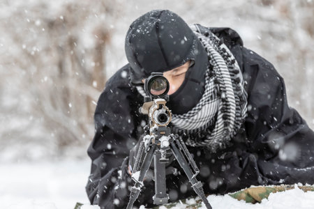 A young soldier trains with his weapon in a harsh snowstorm, braving icy winds and frozen terrain, his focus sharp and determined amid the rugged, wintry outdoor environment.の写真素材