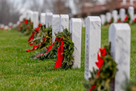 Atop a hill, a veterans cemetery with white headstones and the American flag evokes deep honor, sacrifice, and enduring national pride.の写真素材