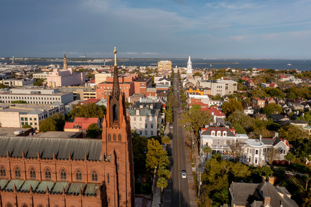 A stunning aerial view of Charleston, South Carolina reveals colorful historic homes, cobblestone streets, and waterfront charm framed by lush trees and shimmering coastal light.のeditorial素材