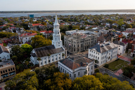 A stunning aerial view of Charleston, South Carolina reveals colorful historic homes, cobblestone streets, and waterfront charm framed by lush trees and shimmering coastal light.のeditorial素材