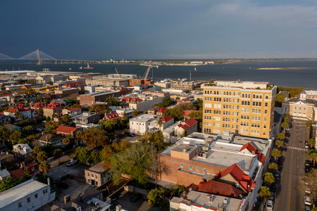 A stunning aerial view of Charleston, South Carolina reveals colorful historic homes, cobblestone streets, and waterfront charm framed by lush trees and shimmering coastal light.のeditorial素材