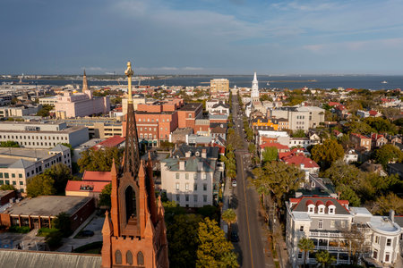 A stunning aerial view of Charleston, South Carolina reveals colorful historic homes, cobblestone streets, and waterfront charm framed by lush trees and shimmering coastal light.のeditorial素材