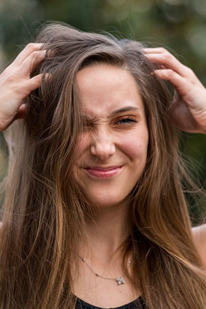 A young woman walks gracefully, soaking in the spring air. Surrounded by blooming flowers and gentle sunshine, she enjoys the calm, peaceful rhythm of the day.の写真素材