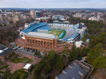 An aerial view of Kenan Stadium in Chapel Hill shows the historic UNC football venue nestled among trees, its classic bowl design anchoring campus since 1927 and home of the Tar Heels.のeditorial素材