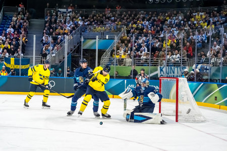 Goalkeeper Juuse Saros #74 of Team Finland makes a save against Team Sweden in the Preliminary Round Group A at the Milano Santagiulia Ice Hockey Arena in MILAN, Italy during the 2026 Milano Cortina Winter Olympics.  Finland defeats Sweden, 4:1.のeditorial素材