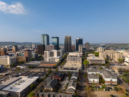 An aerial view of Birmingham reveals a vibrant city framed by rolling hills, blending historic industrial roots with modern skylines, thriving neighborhoods, and a dynamic hub of business, education, and culture.のeditorial素材
