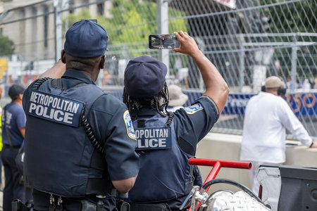 Security personnel are stationed throughout the track during the Freedom 250 Grand Prix in WASHINGTON, DC, highlighting event safety, crowd control, and security operations at the motorsports event.