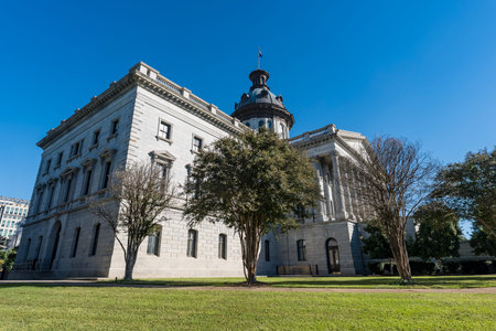 The South Carolina State House rises over its green lawn under a clear blue sky in Columbia