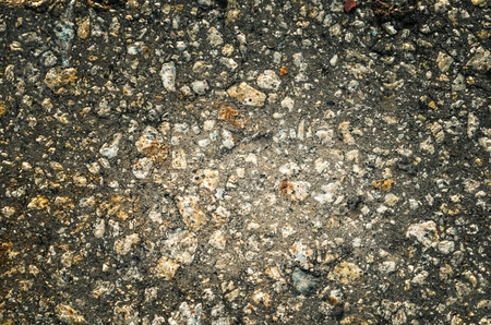 Dark stone background. Texture of pebbles with vignette.