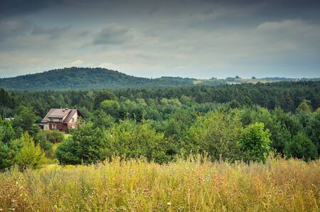 Cloudy rural landscape. Country house among the green hills.のeditorial素材