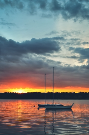 Beautiful summer evening landscape. Boats on the lake at sunset.の写真素材