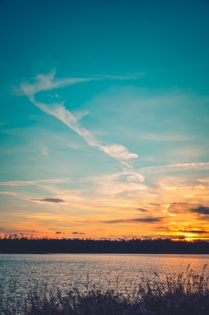 Beautiful sunset landscape. Colorful sky and lake shore.の写真素材