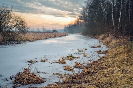 Colorful winter morning. A frozen river with a beautiful sunrise.の写真素材