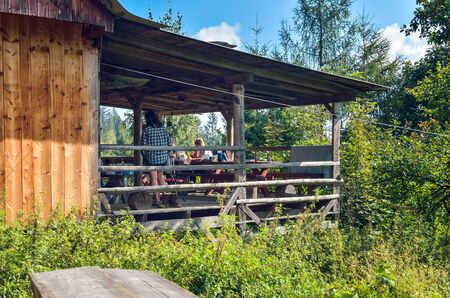 BESKIDS, POLAND - SEPTEMBER 9, 2018: Tourists on the porch in front of a mountain hostel in the Beskids in Poland.のeditorial素材