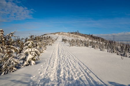 Beautiful winter mountain landscape. White snow trail in the mountains and blue sky.の写真素材