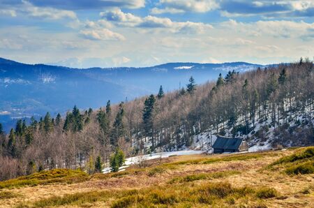 Fabulous spring mountain landscape. Wooden cabin on a clearing on a hill.の写真素材