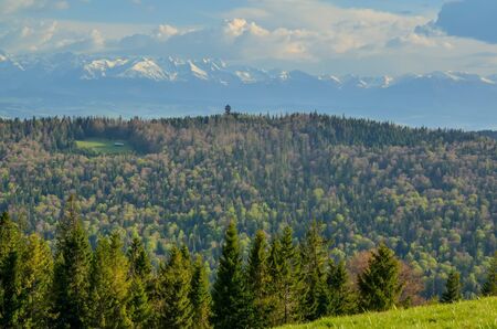 Charming spring mountain landscape. Beautifully snow-covered high peaks over hills.の写真素材