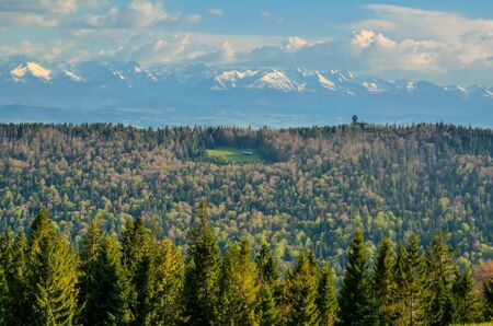 Charming spring mountain landscape. Beautifully snow-covered high peaks over hills.の写真素材