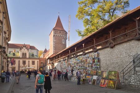 KRAKOW, POLAND - OCTOBER 13, 2018: Tourists at the stand with paintings on the market in Krakow, Poland.のeditorial素材