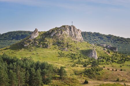 Sunny summer landscape. Beautiful rocks with a cross at the top.の写真素材