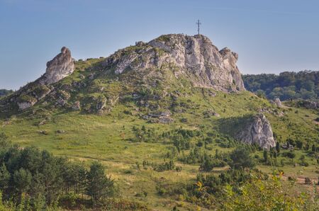 Sunny summer landscape. Beautiful rocks with a cross at the top.の写真素材