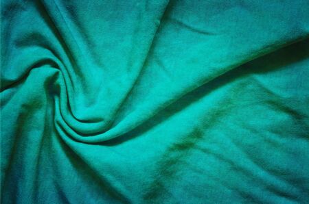 Interesting conceptual background with clothes. Texture of turquoise wrinkled material.の写真素材
